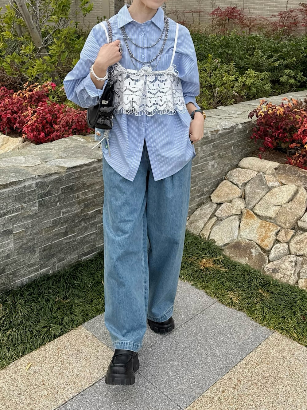 ブルー系のデニムパンツ、ホワイト系のキャミソール、ブラック系のローファーを着用したレディースの春コーディネートの3枚目の写真