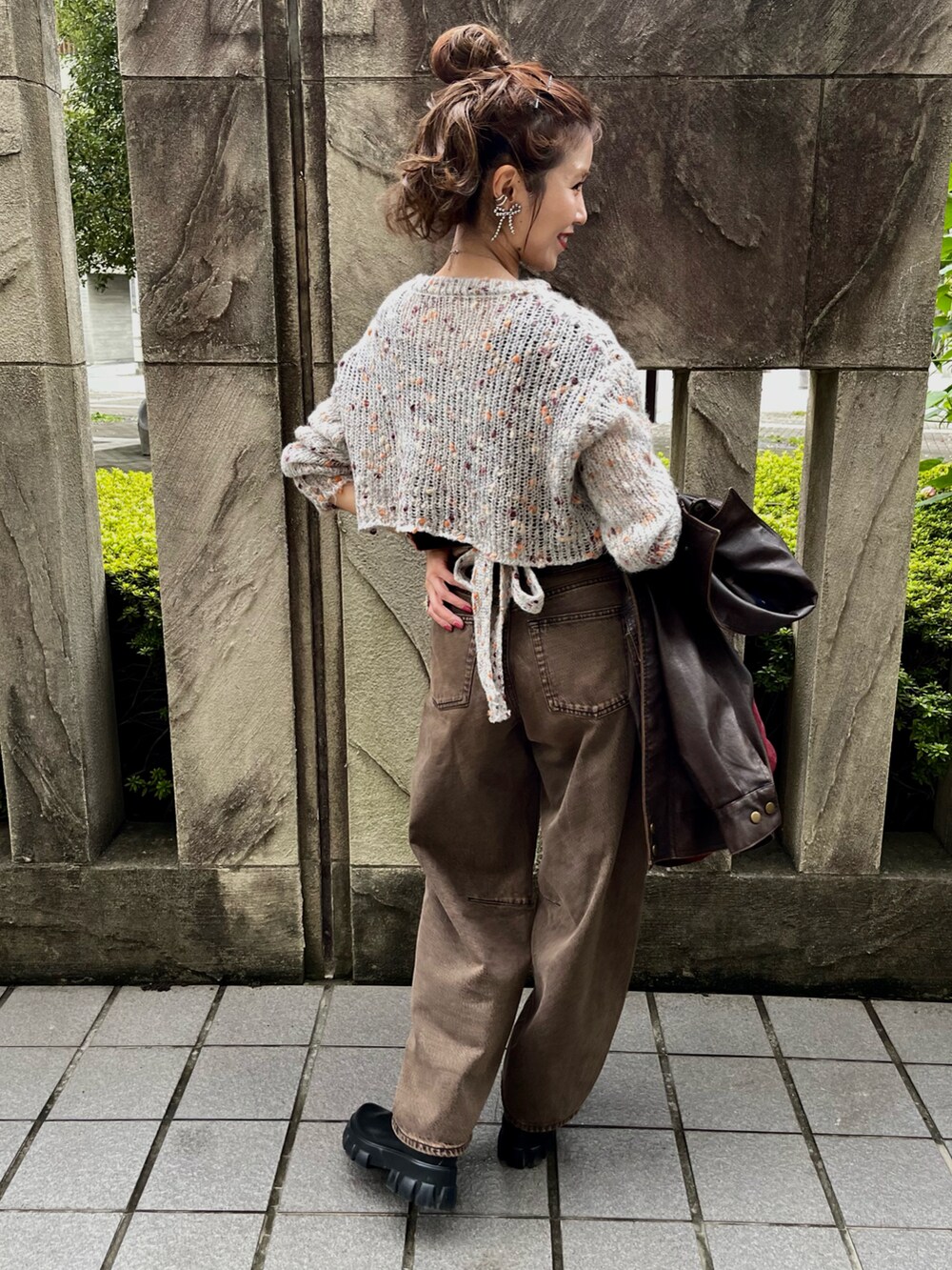 ベージュ系のニット/セーター、ブラウン系のデニムパンツ、レッド系のトートバッグを着用したレディースの冬コーディネートの4枚目の写真