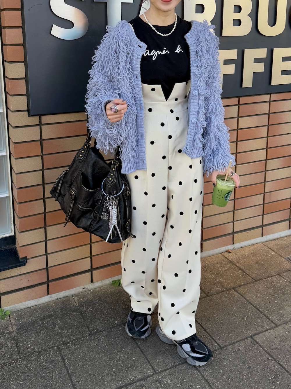 ブラック系のTシャツ/カットソー、ブルー系のカーディガン/ボレロ、ブラック系のトートバッグを着用したレディースの冬コーディネートの3枚目の写真