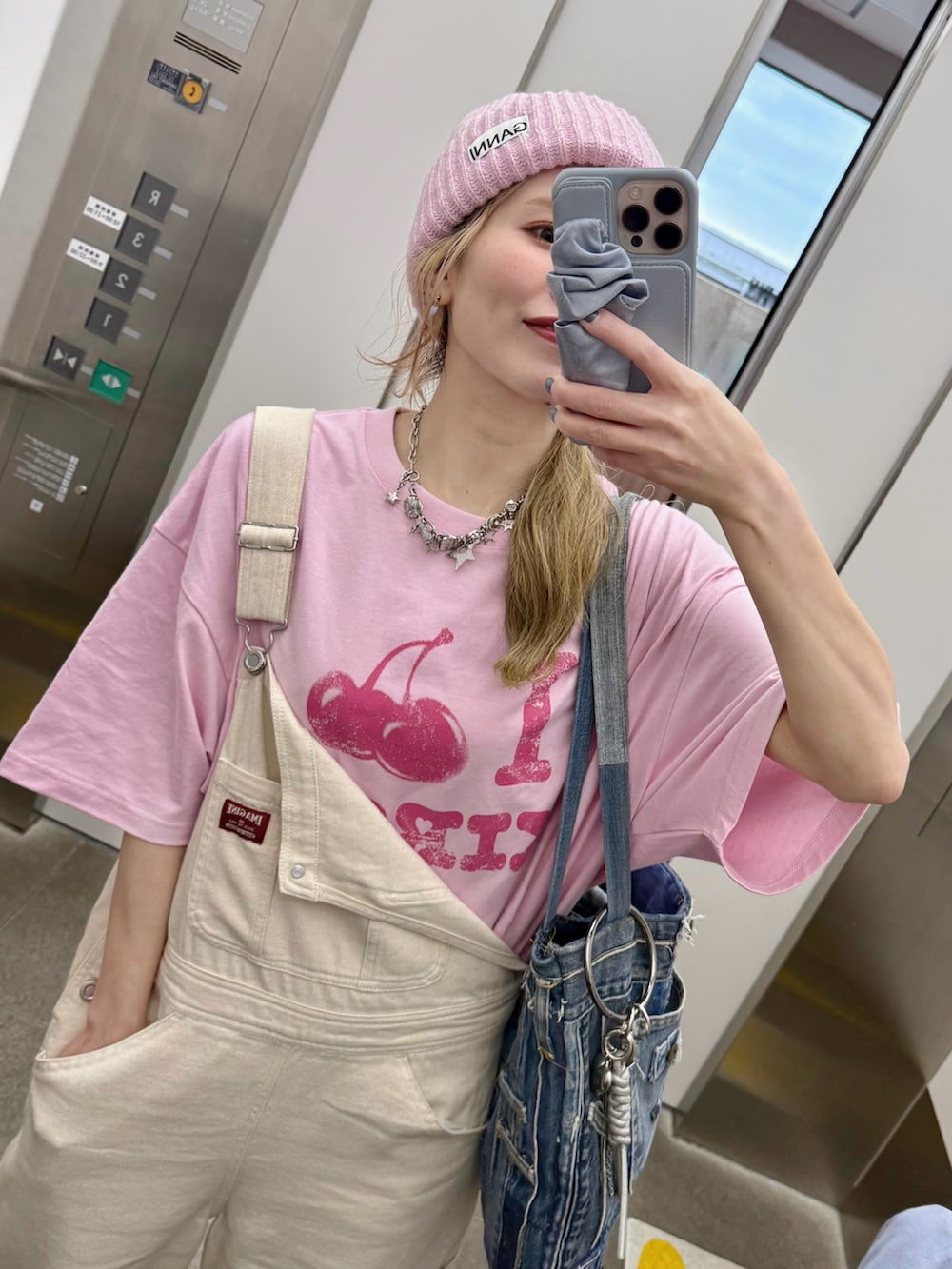 ホワイト系のスニーカー、ピンク系のTシャツ/カットソー、ホワイト系のヘッドフォン/イヤホンを着用したレディースの春コーディネートの4枚目の写真