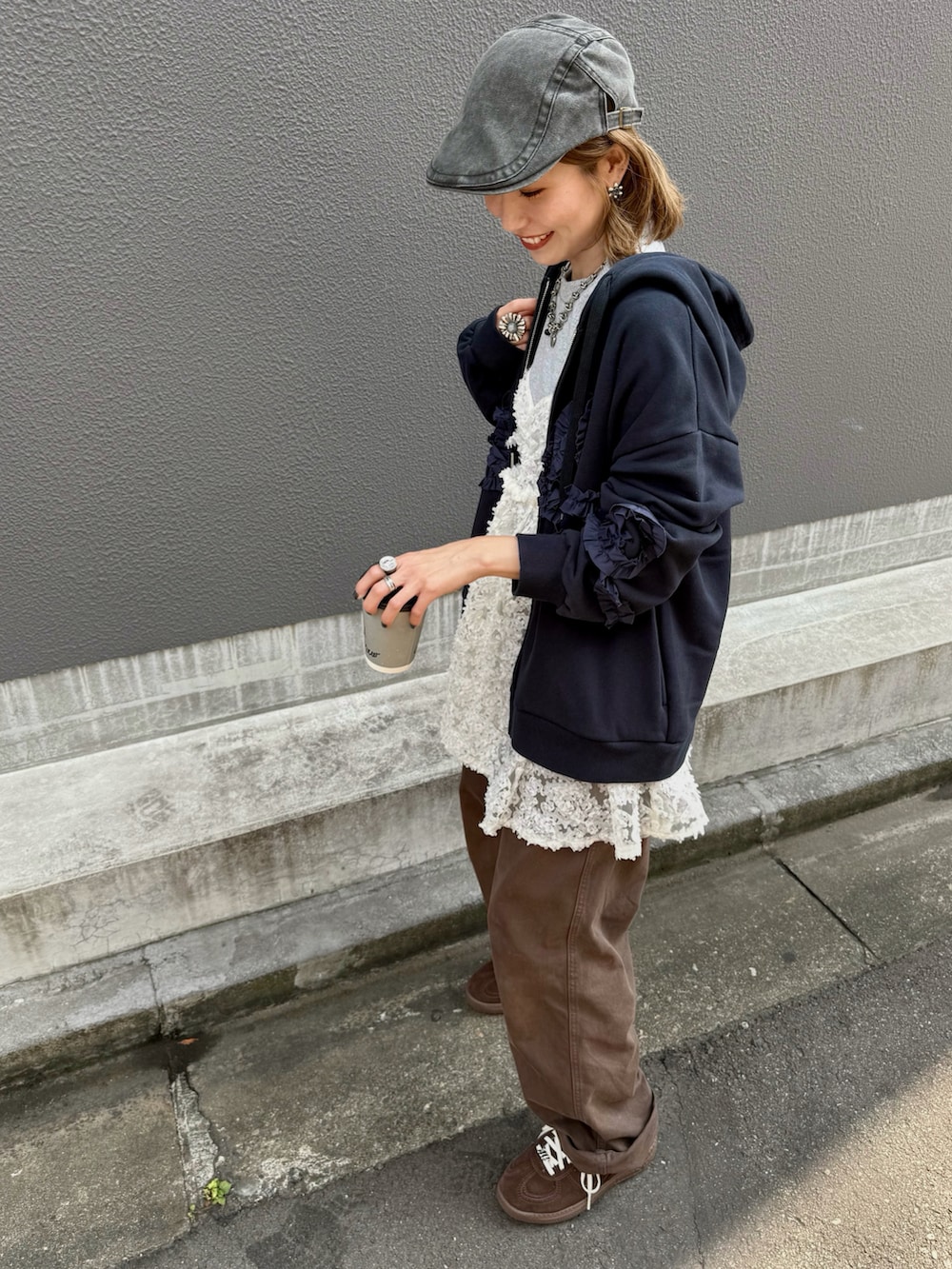 ホワイト系のチュニック、ブラウン系のスニーカー、ブルー系のパーカーを着用したレディースの秋コーディネートの4枚目の写真