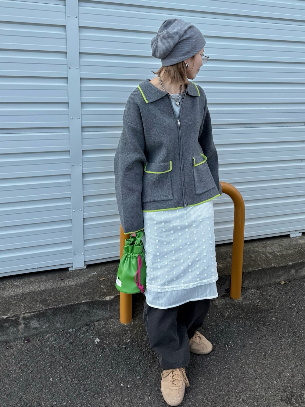 グレー系のカーディガン/ボレロ、ホワイト系のワンピース、グリーン系のハンドバッグを着用したレディースの秋コーディネートの2枚目の写真