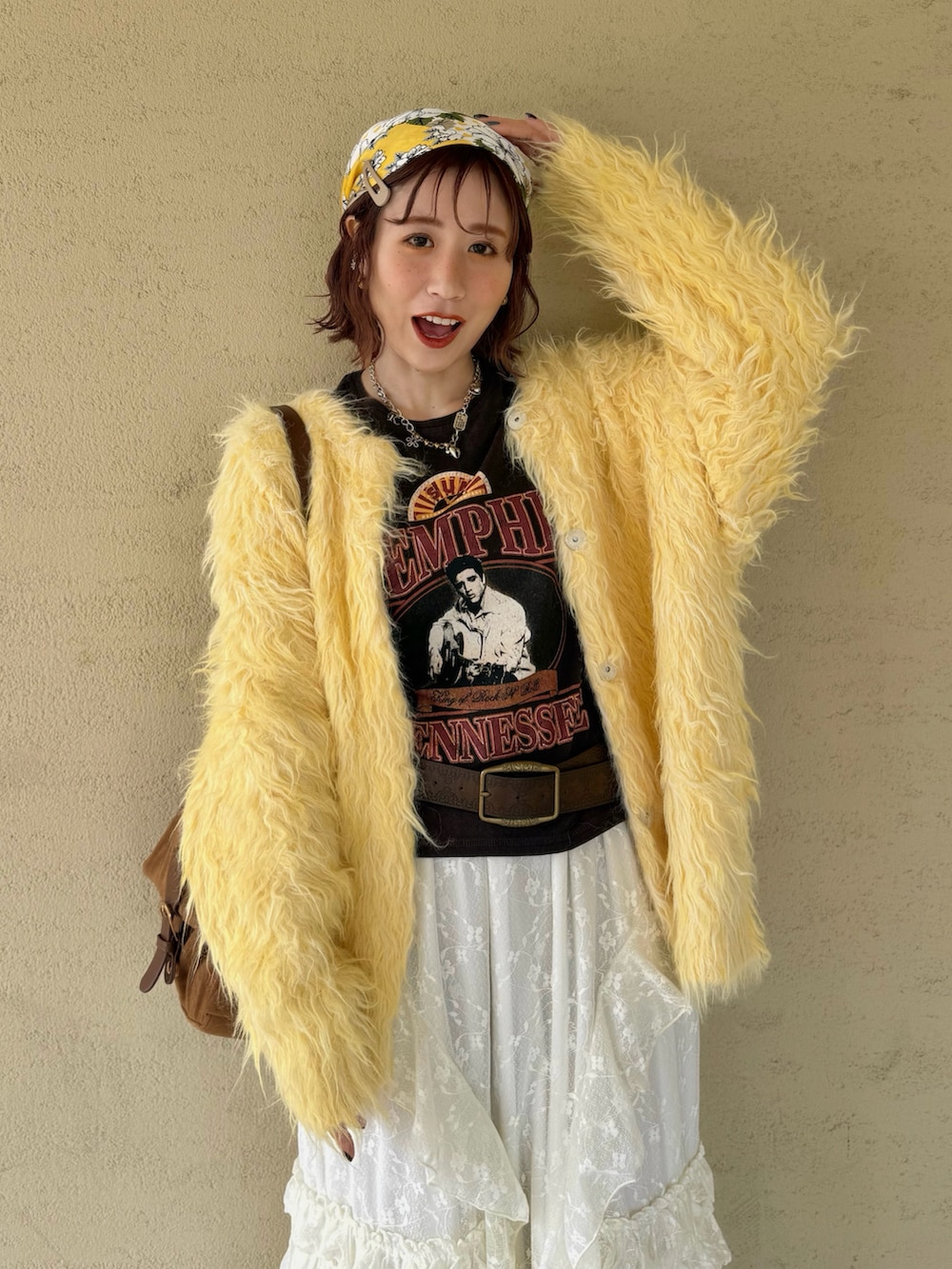 イエロー系のカーディガン/ボレロ、ブラウン系のブーツ、ホワイト系のスカートを着用したレディースの冬コーディネートの3枚目の写真