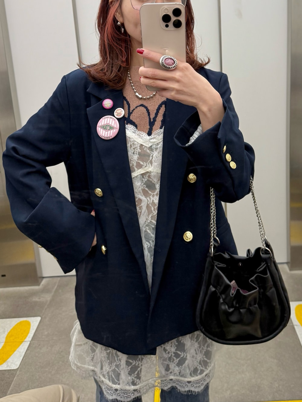 ブルー系のテーラードジャケット、ホワイト系のキャミソール、ブルー系のデニムパンツを着用したレディースの冬コーディネートの3枚目の写真