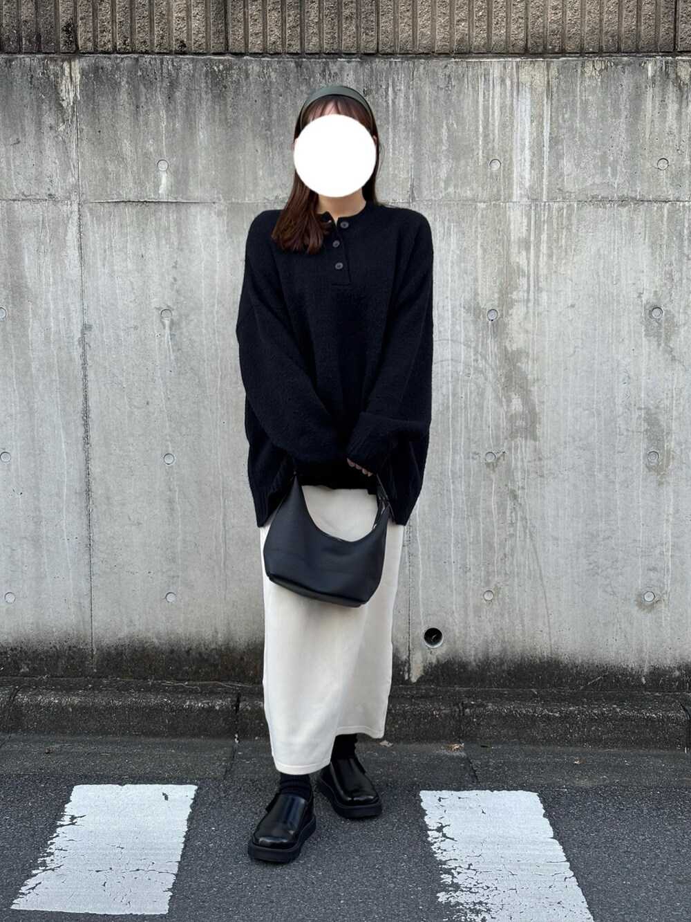 ブラック系のシューズ、ホワイト系のスカート、ブラック系のニット/セーターを着用したレディースの冬コーディネートの3枚目の写真