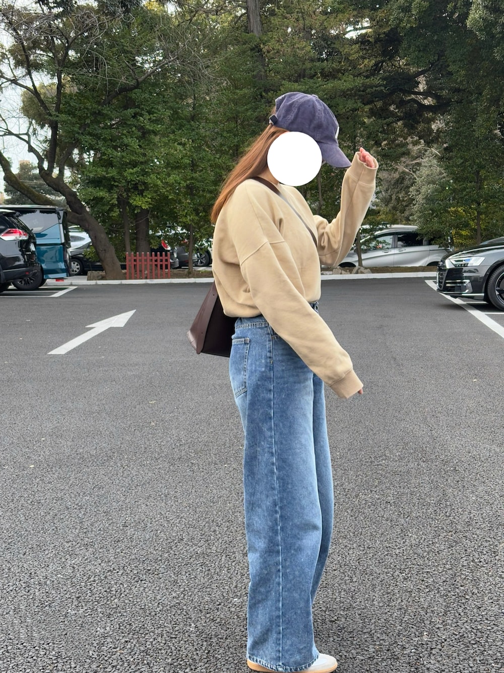 ブルー系のデニムパンツ、ベージュ系のスウェットを着用したレディースの冬コーディネートの2枚目の写真