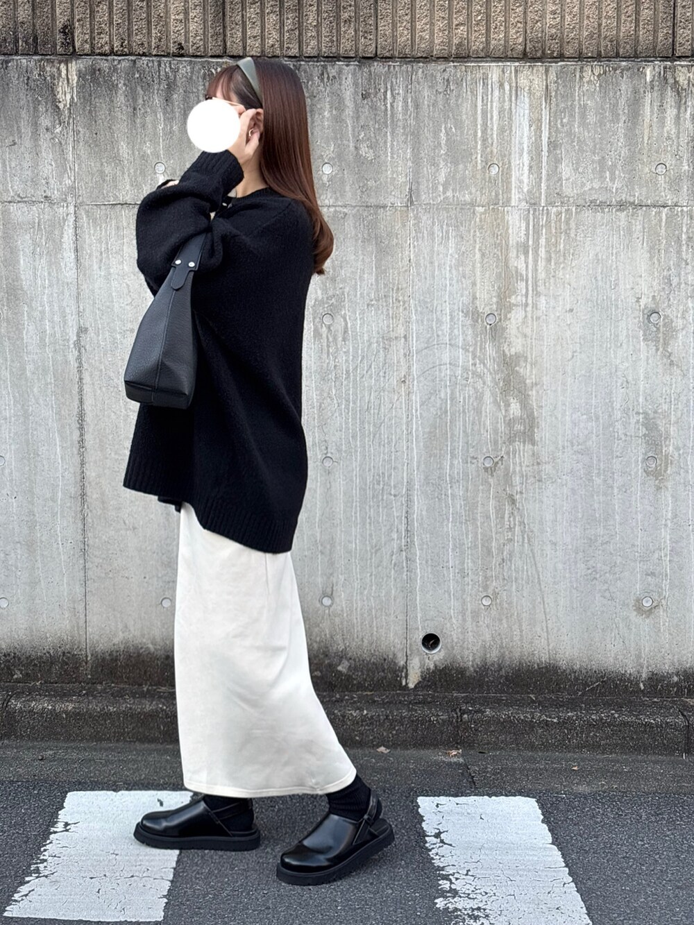 ブラック系のシューズ、ホワイト系のスカート、ブラック系のニット/セーターを着用したレディースの冬コーディネートの4枚目の写真
