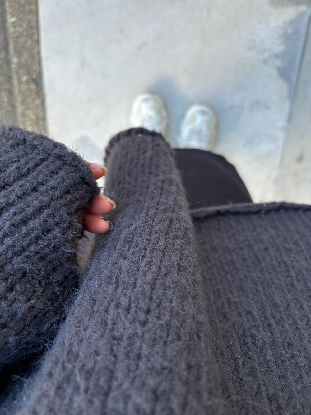 ブラック系のスカート、グレー系のニット/セーターを着用したレディースの秋コーディネートの3枚目の写真