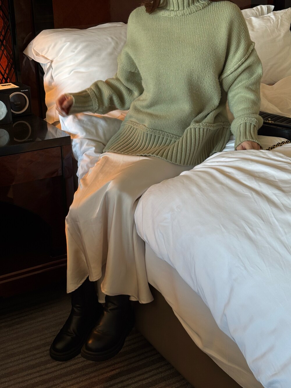 グリーン系のニット/セーター、ブラック系のショルダーバッグ、ブラック系のブーツを着用したレディースの冬コーディネートの2枚目の写真