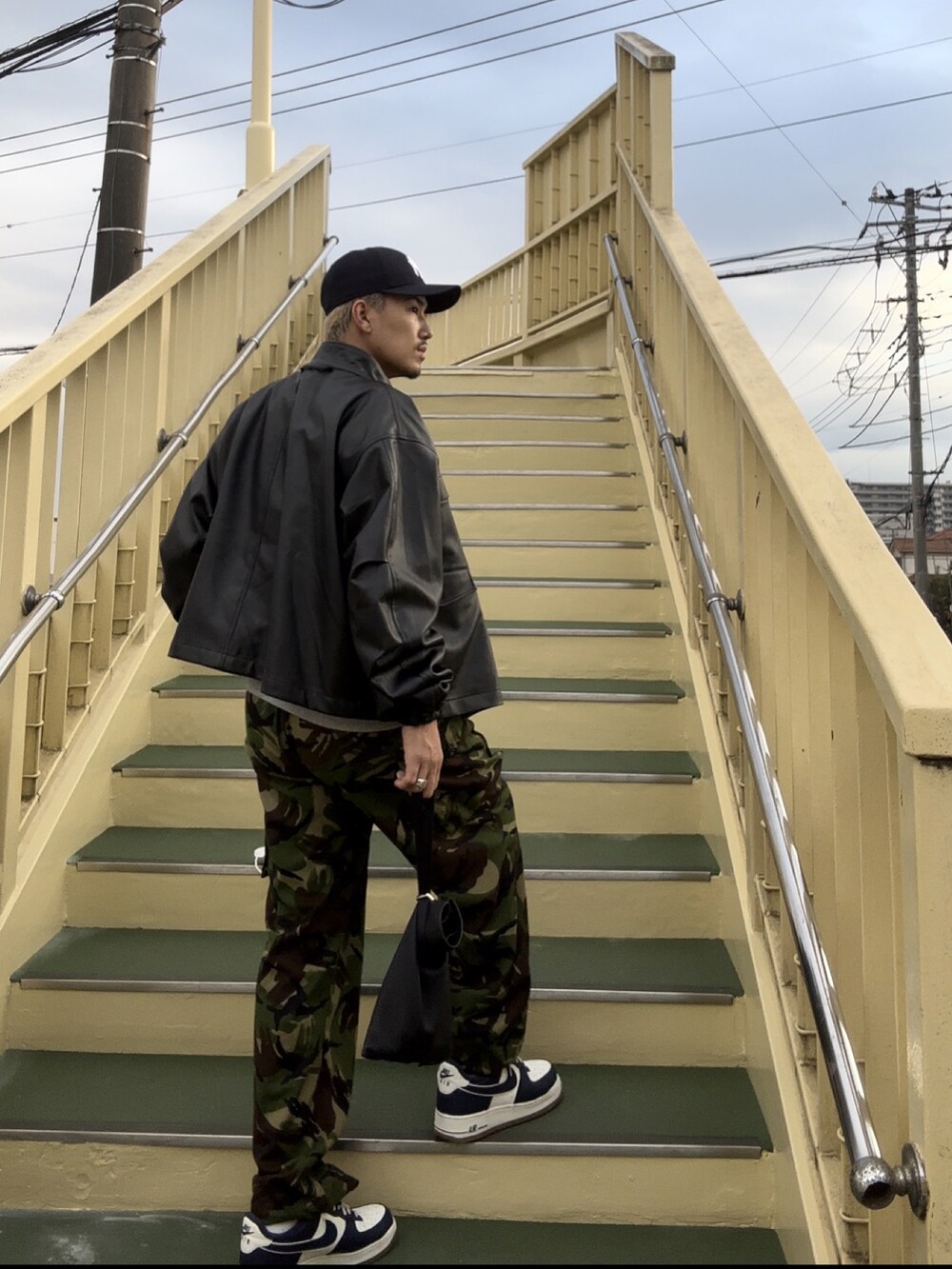 ブラック系のブルゾン、ブルー系のキャップを着用したメンズの秋コーディネートの2枚目の写真