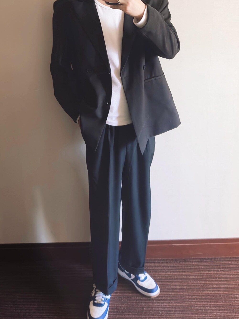 ブラック系のテーラードジャケット、ブラック系のスラックス、ブルー系のスニーカーを着用したメンズの秋コーディネートの2枚目の写真