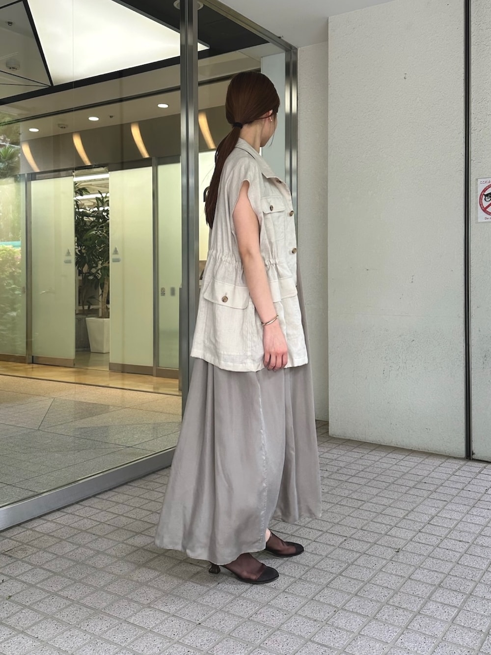 ベージュ系のワンピース、ベージュ系のベスト、ブラウン系のサンダルを着用したレディースの夏コーディネートの3枚目の写真