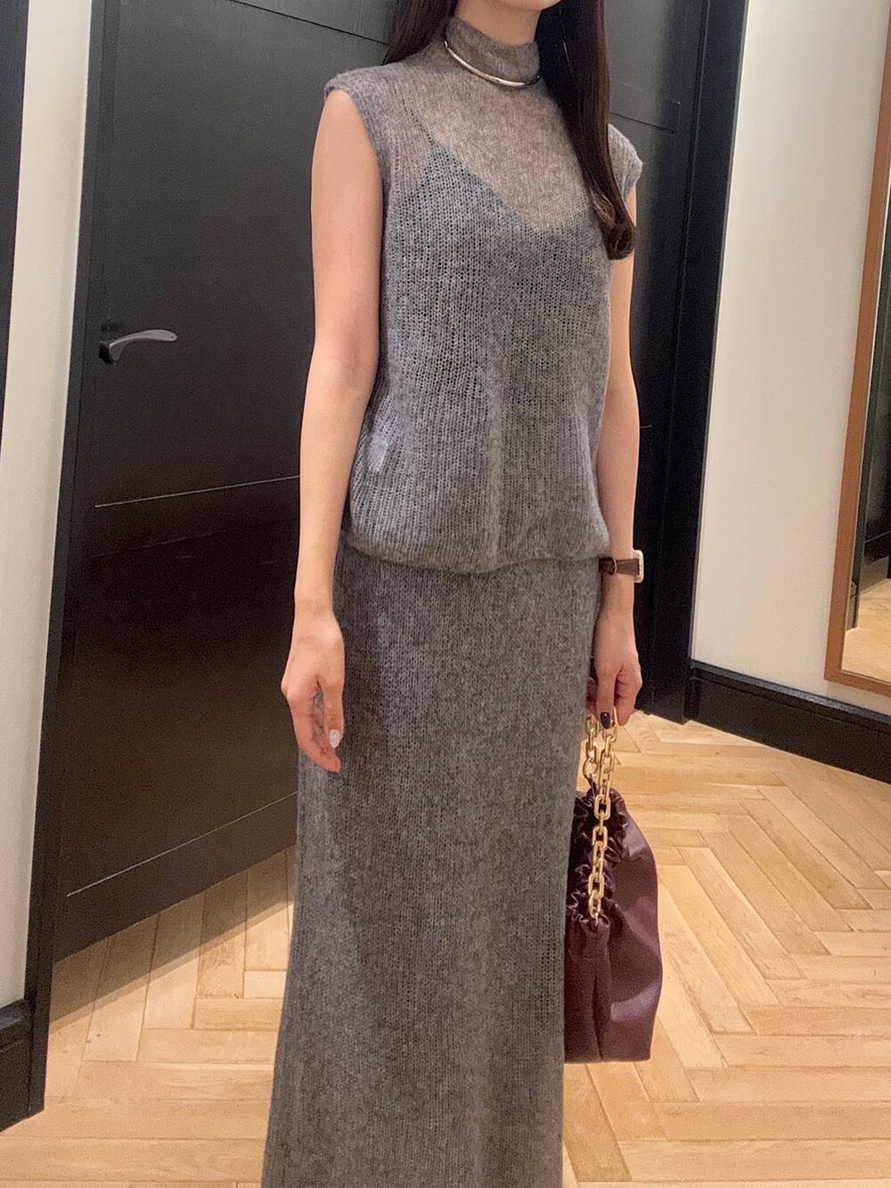 グレー系のワンピース、レッド系のショルダーバッグ、ブラック系のブーツを着用したレディースの秋コーディネートの5枚目の写真