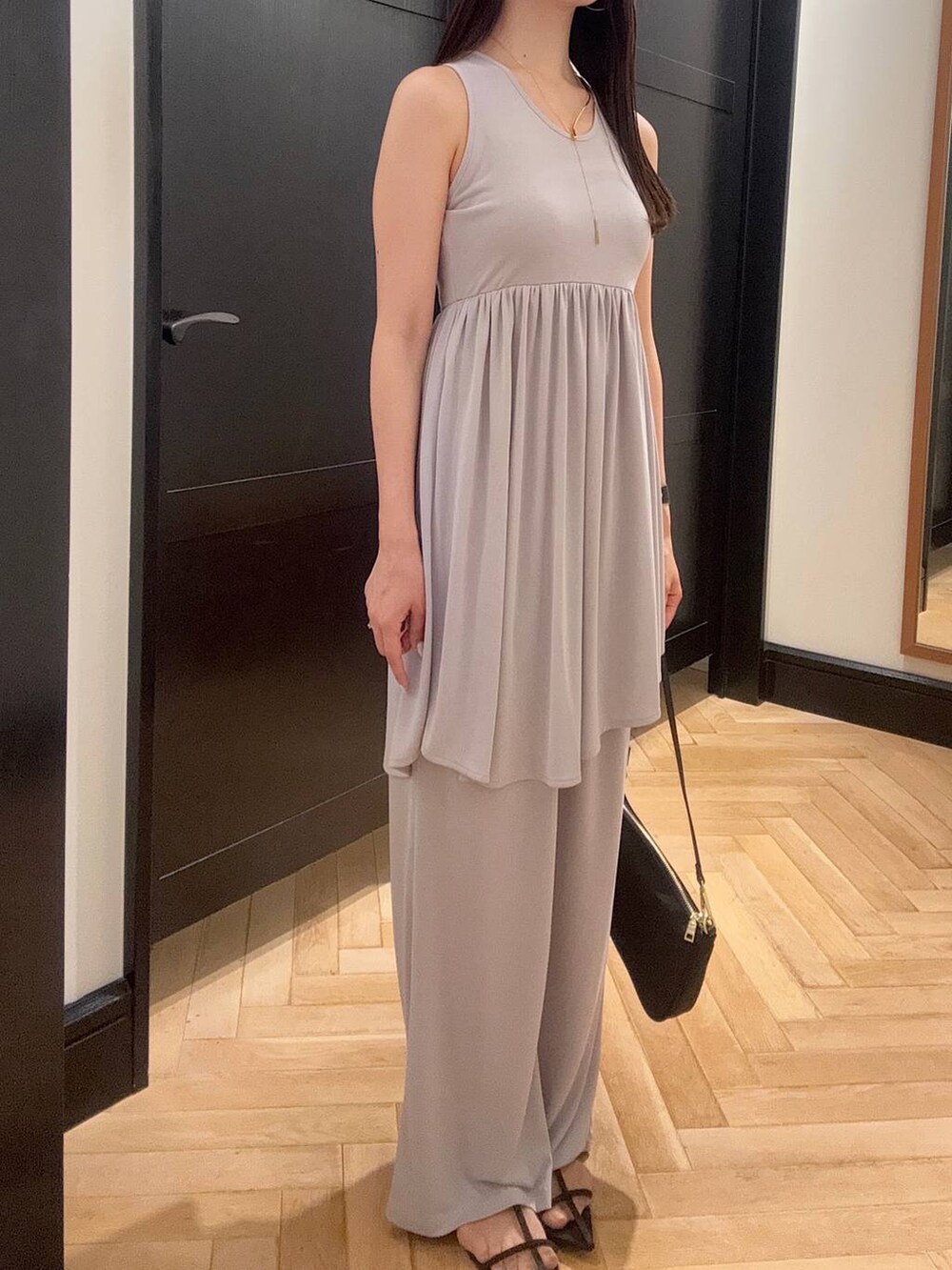 ブラウン系のサンダル、グレー系のセットアップ、ブラック系のショルダーバッグを着用したレディースの夏コーディネートの4枚目の写真