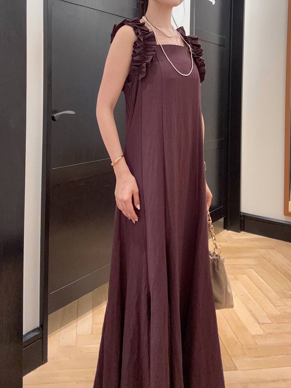 ブラウン系のパンプス、ブラウン系のワンピース、ベージュ系のショルダーバッグを着用したレディースの夏コーディネートの4枚目の写真