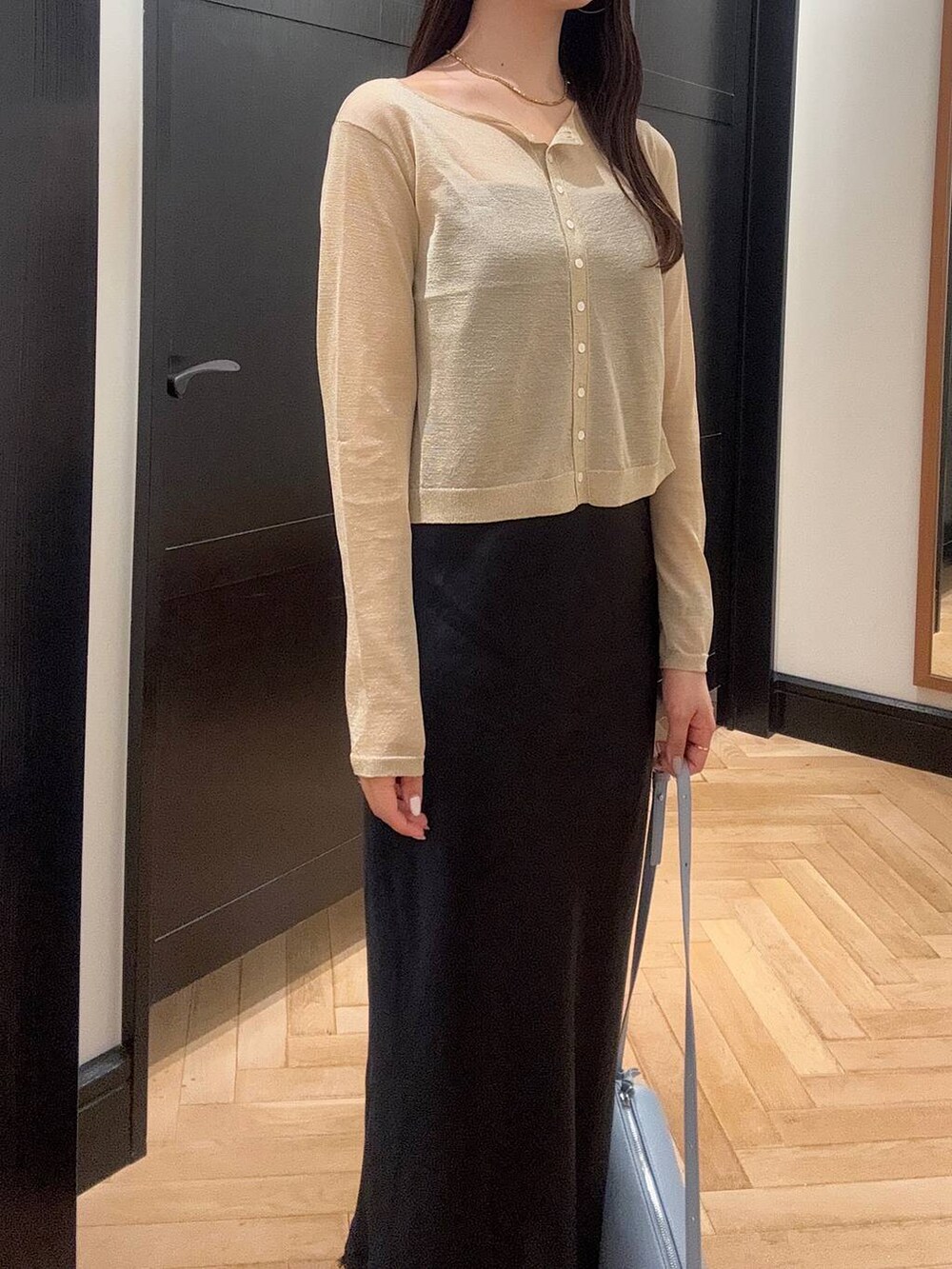 ブルー系のハンドバッグ、ブラウン系のパンプス、ブルー系のワンピースを着用したレディースの夏コーディネートの5枚目の写真