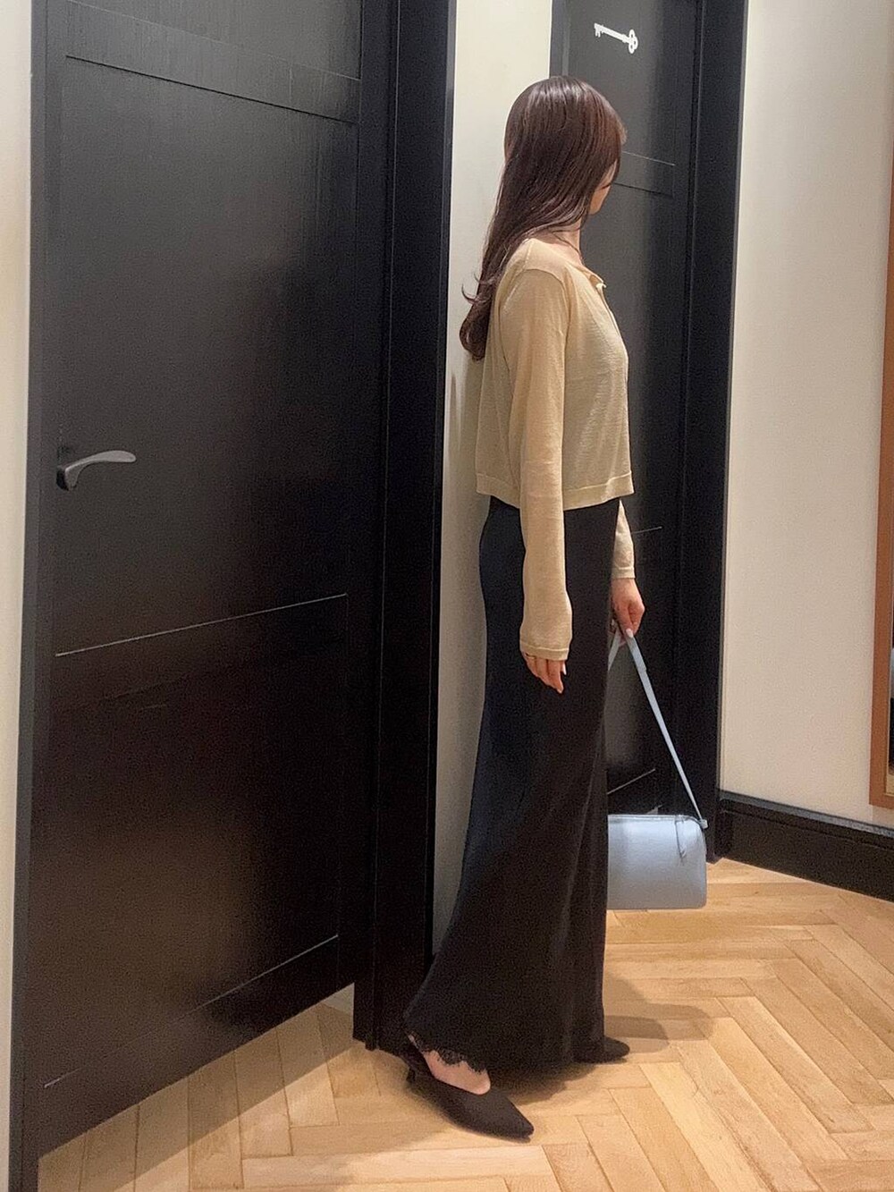 ブルー系のハンドバッグ、ブラウン系のパンプス、ブルー系のワンピースを着用したレディースの夏コーディネートの2枚目の写真