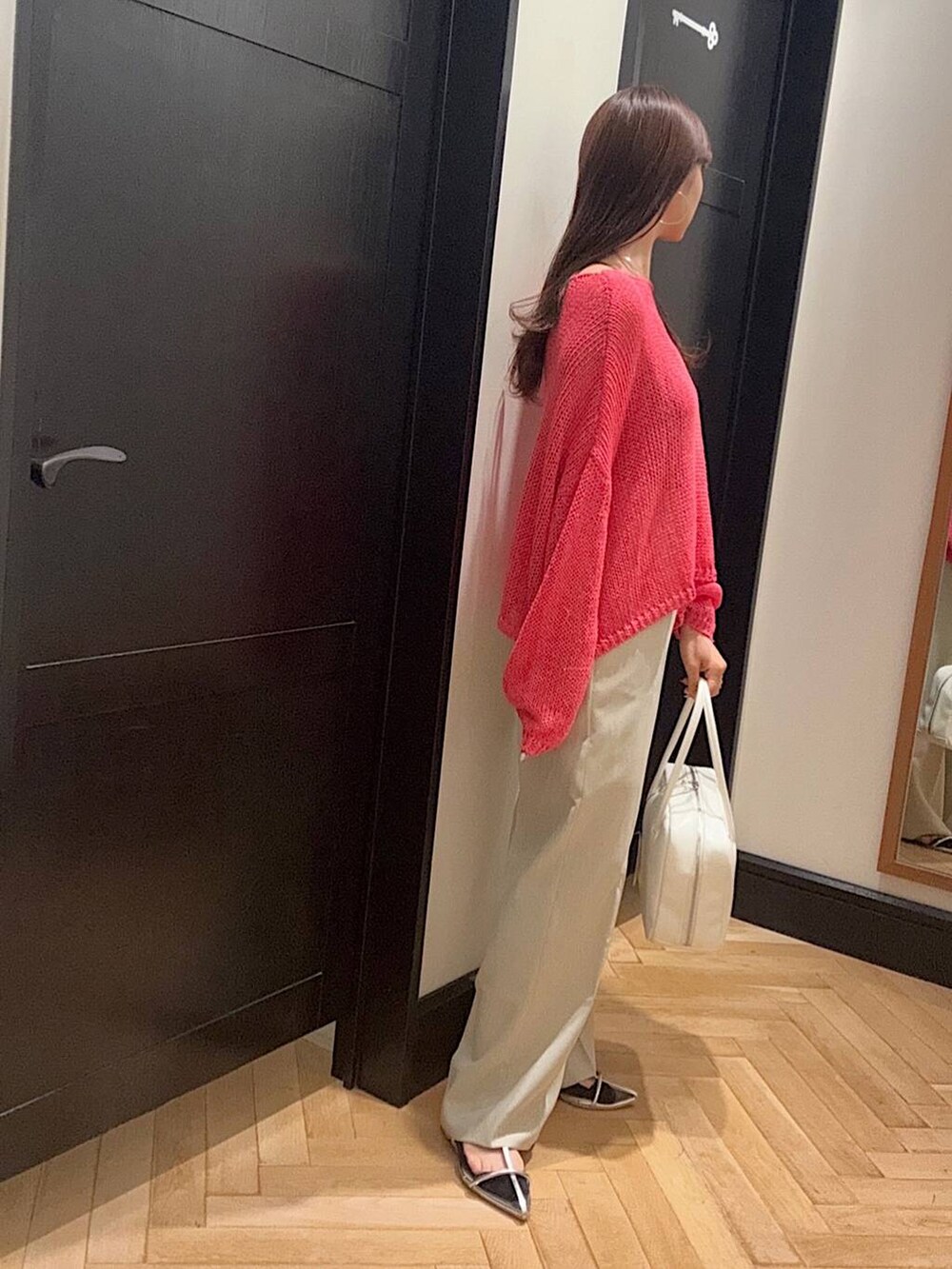 ホワイト系のボストンバッグ、シルバー系のサンダル、ベージュ系のスラックスを着用したレディースの春コーディネートの2枚目の写真