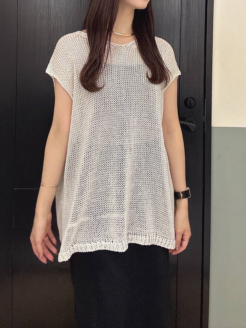 ブラック系のスカート、ホワイト系のニット/セーター、グレー系のニット/セーターを着用したレディースの夏コーディネートの2枚目の写真