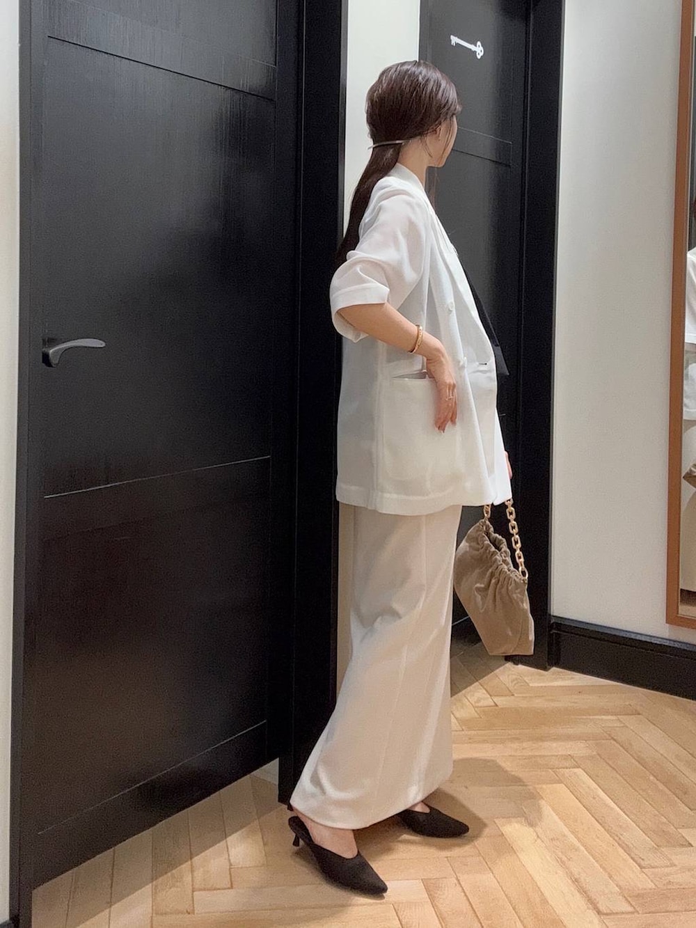 ホワイト系のテーラードジャケット、ブラック系のセットアップ、ブラウン系のパンプスを着用したレディースの夏コーディネートの2枚目の写真