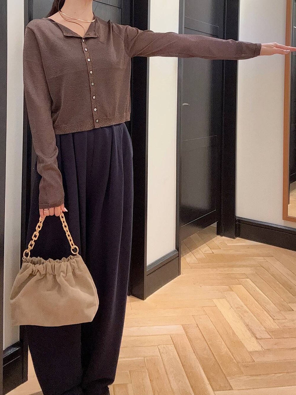 ブルー系のスウェットパンツ、ブラウン系のパンプス、ベージュ系のショルダーバッグを着用したレディースの夏コーディネートの5枚目の写真