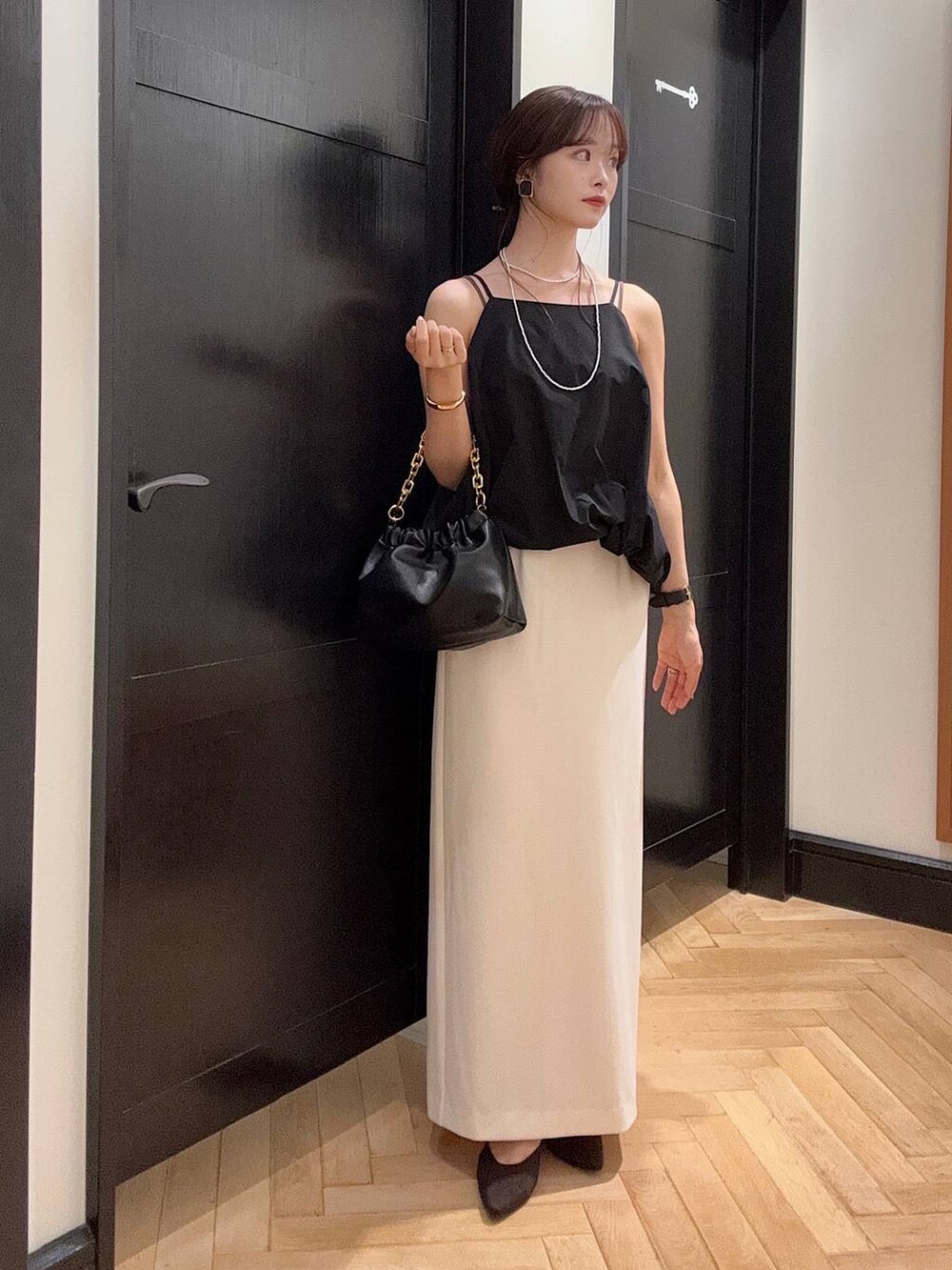 ホワイト系のテーラードジャケット、ブラック系のセットアップ、ブラウン系のパンプスを着用したレディースの夏コーディネートの3枚目の写真