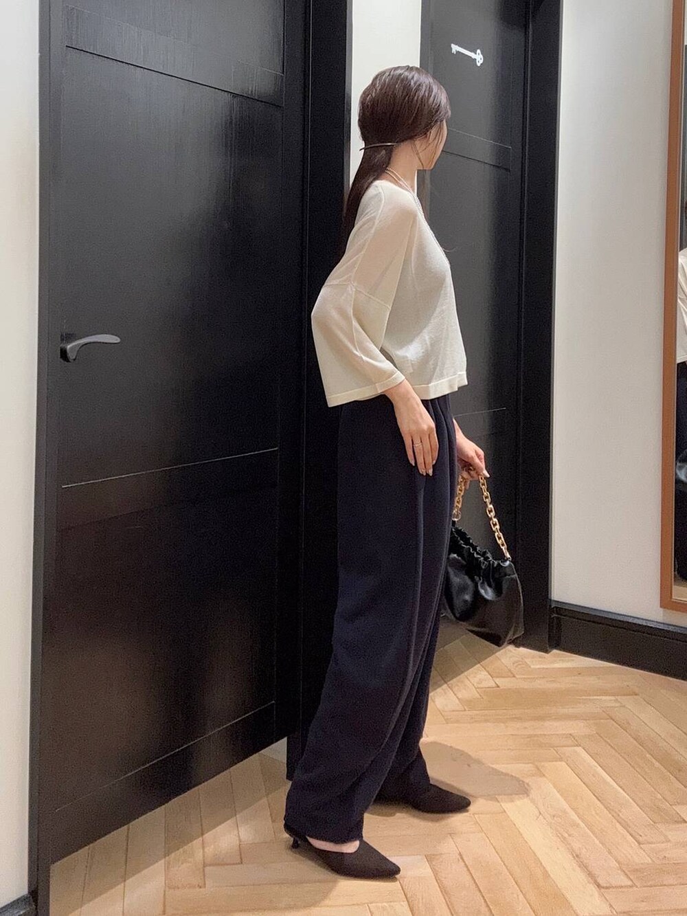 ブルー系のスウェットパンツ、ホワイト系のニット/セーター、ブラウン系のパンプスを着用したレディースの夏コーディネートの2枚目の写真