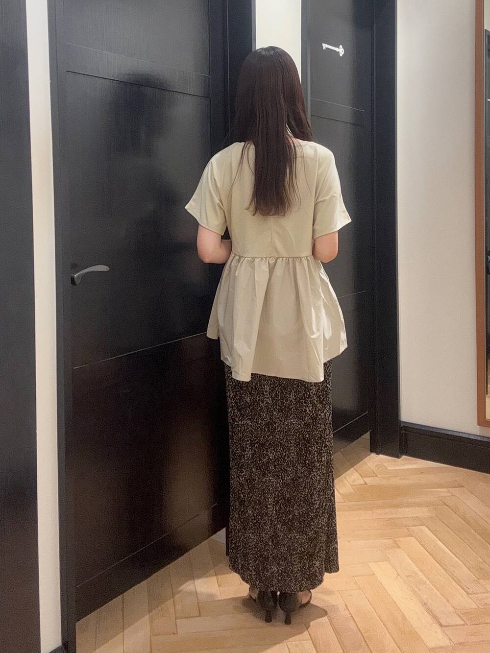 ブラウン系のスカート、ブラック系のパンプス、ブラック系のショルダーバッグを着用したレディースの夏コーディネートの3枚目の写真