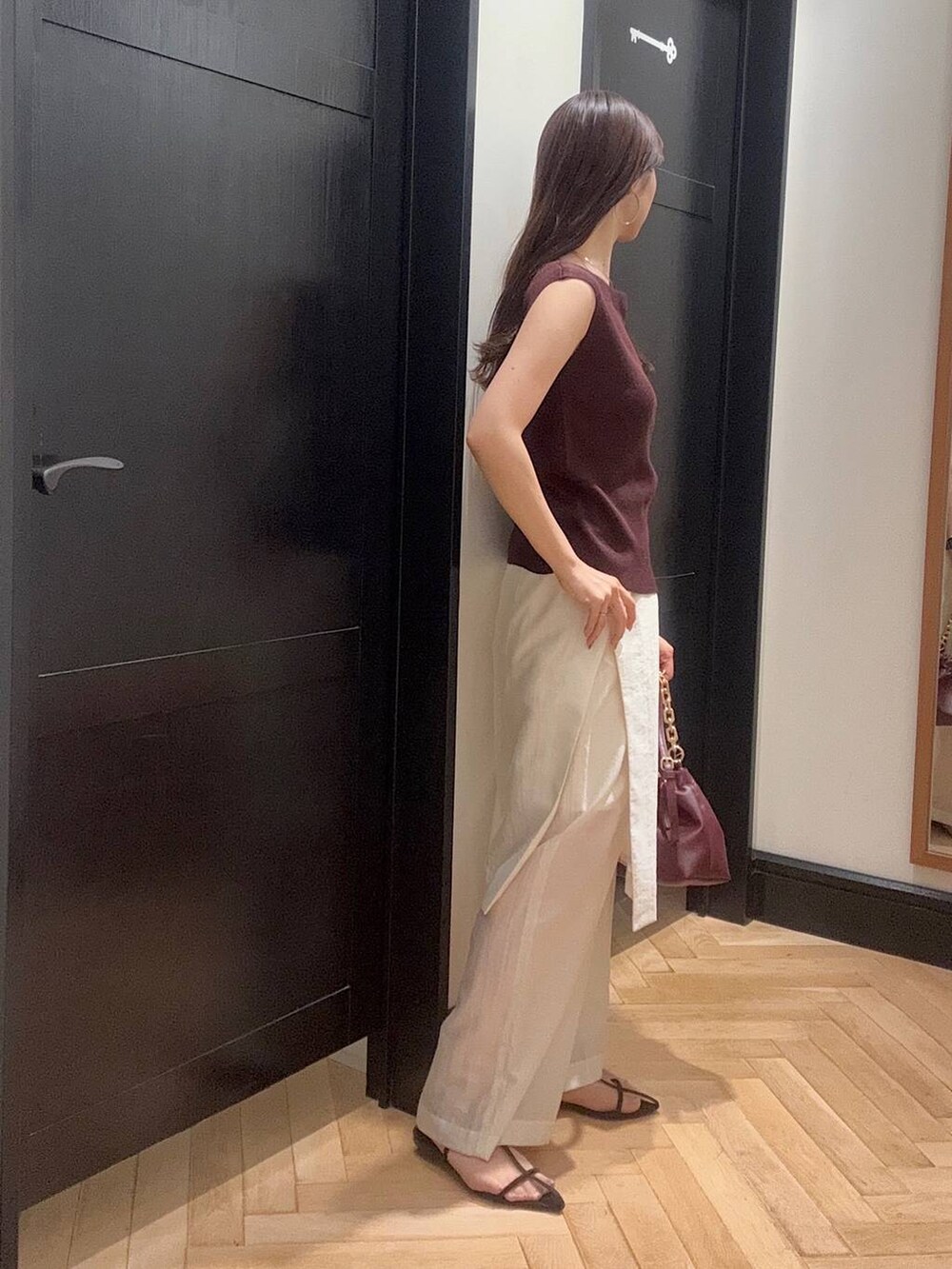 ブラウン系のサンダル、レッド系のニット/セーター、ホワイト系のその他パンツを着用したレディースの夏コーディネートの2枚目の写真