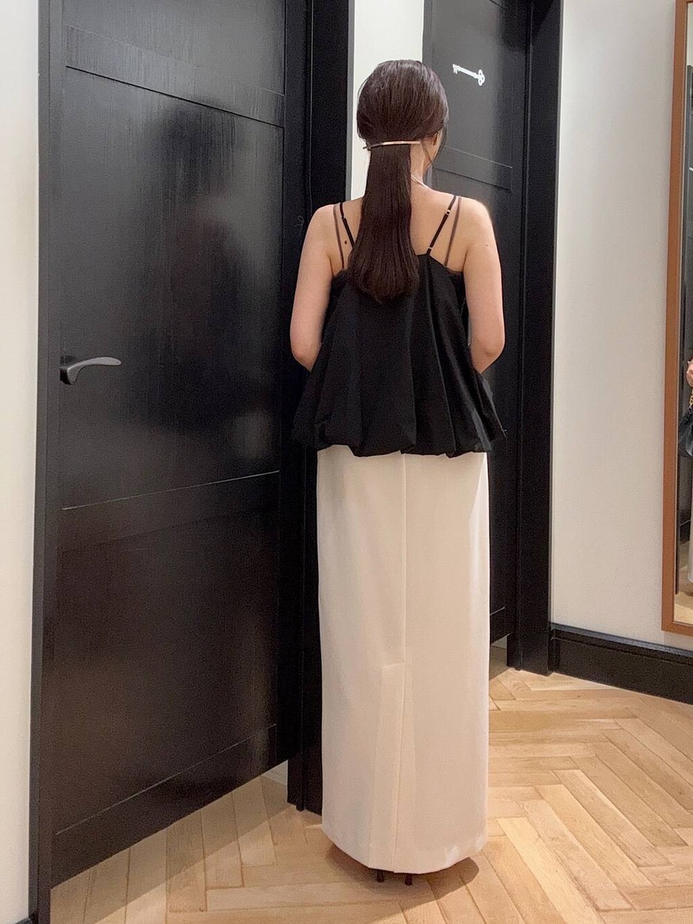 ホワイト系のセットアップ、ブラウン系のパンプス、ブラック系のショルダーバッグを着用したレディースの夏コーディネートの4枚目の写真