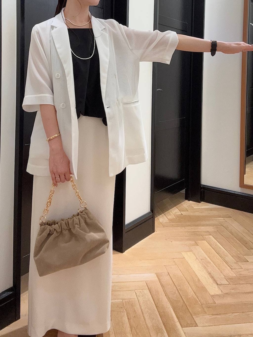 ホワイト系のテーラードジャケット、ブラック系のセットアップ、ブラウン系のパンプスを着用したレディースの夏コーディネートの7枚目の写真