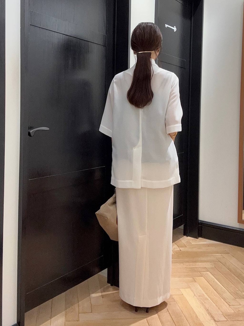 ホワイト系のテーラードジャケット、ブラック系のセットアップ、ブラウン系のパンプスを着用したレディースの夏コーディネートの4枚目の写真