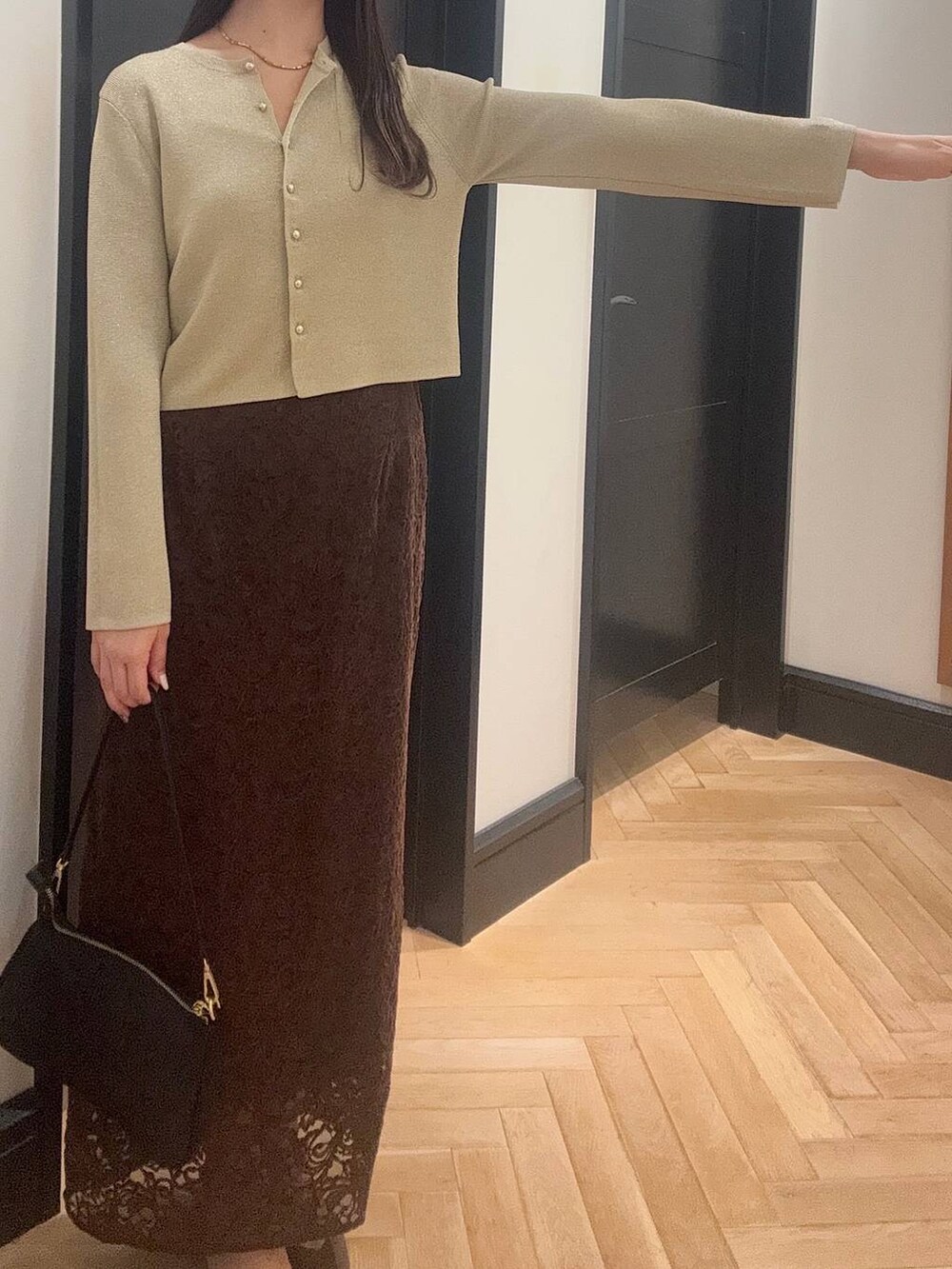 ゴールド系のカーディガン/ボレロ、ブラウン系のスカート、ブラック系のショルダーバッグを着用したレディースの夏コーディネートの5枚目の写真