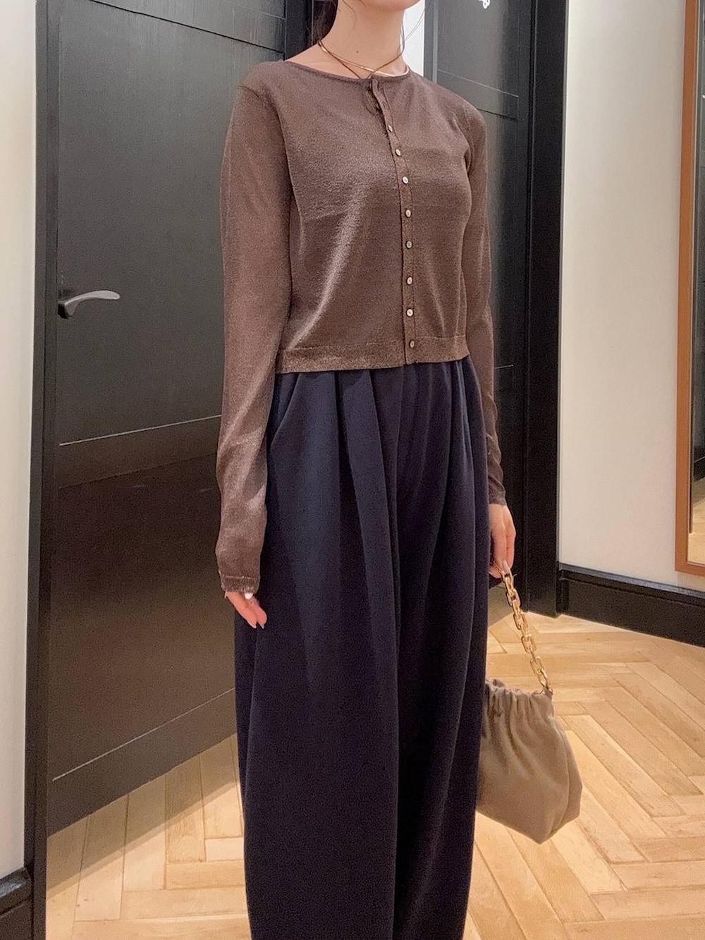 ブルー系のスウェットパンツ、ブラウン系のパンプス、ベージュ系のショルダーバッグを着用したレディースの夏コーディネートの4枚目の写真