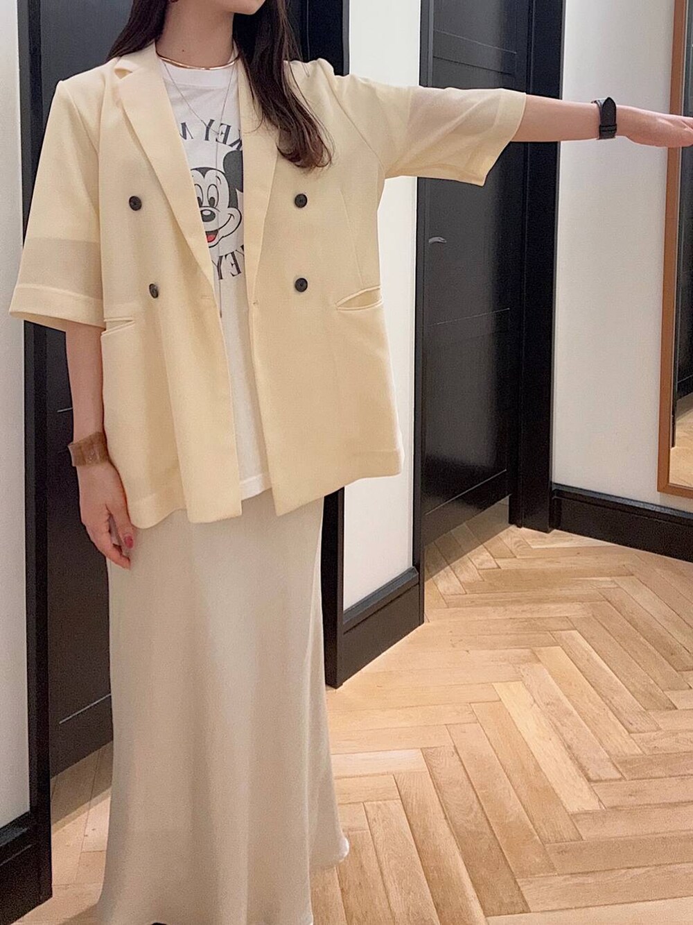 ホワイト系のスカート、ホワイト系のTシャツ/カットソー、ブラック系のスニーカーを着用したレディースの夏コーディネートの4枚目の写真