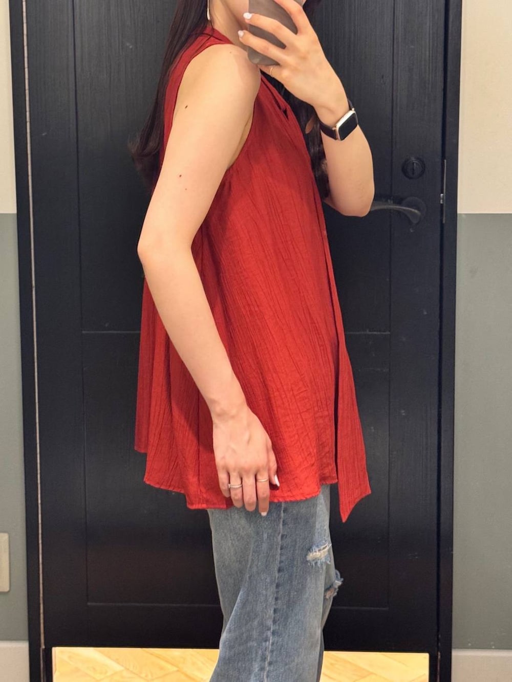 ブルー系のデニムパンツ、オレンジ系のTシャツ/カットソー、シルバー系のネックレスを着用したレディースの夏コーディネートの2枚目の写真