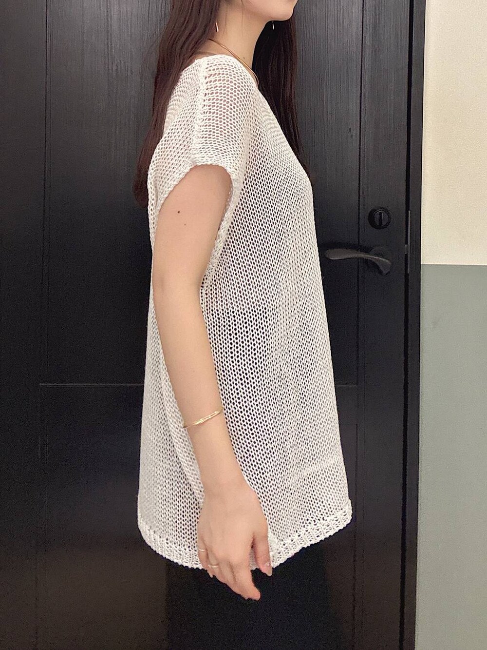 ブラック系のスカート、ホワイト系のニット/セーター、グレー系のニット/セーターを着用したレディースの夏コーディネートの3枚目の写真