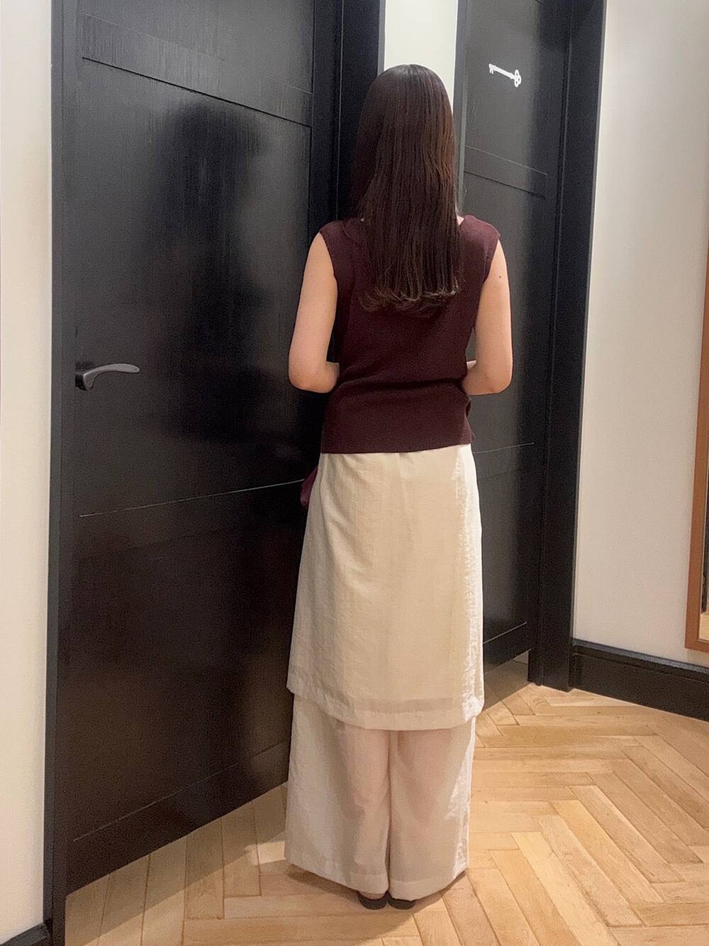 ブラウン系のサンダル、レッド系のニット/セーター、ホワイト系のその他パンツを着用したレディースの夏コーディネートの3枚目の写真