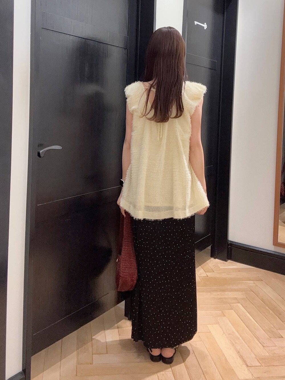 ブラウン系のハンドバッグ、その他のスカート、ブラック系のパンプスを着用したレディースの夏コーディネートの3枚目の写真