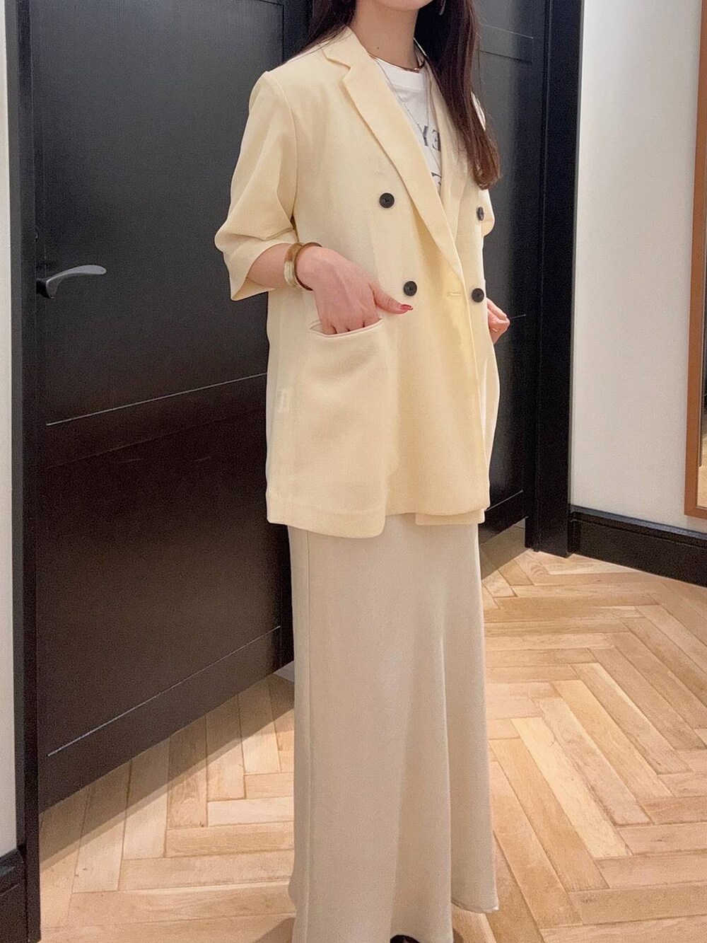 ホワイト系のスカート、ホワイト系のTシャツ/カットソー、ブラック系のスニーカーを着用したレディースの夏コーディネートの5枚目の写真