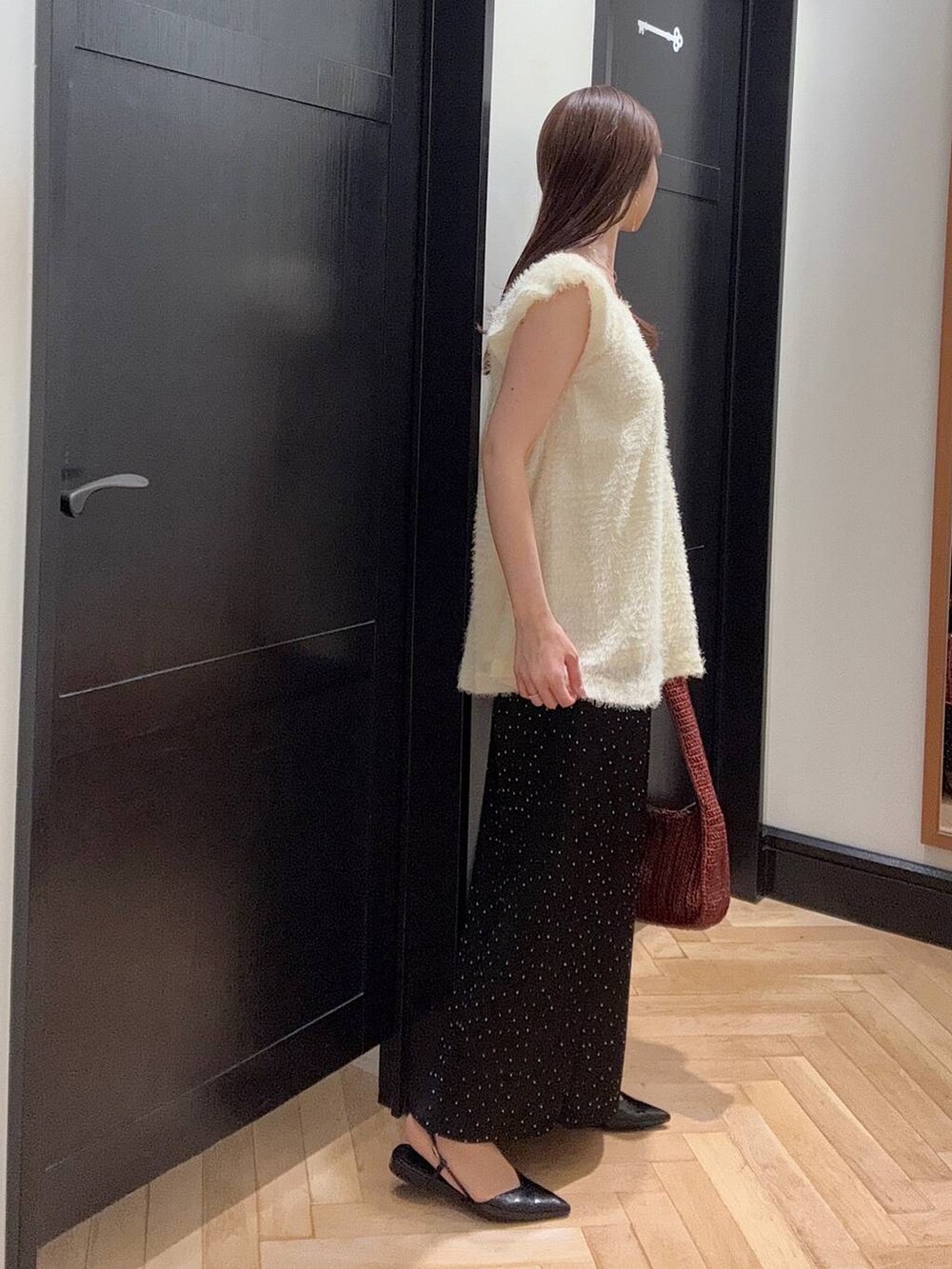 ブラウン系のハンドバッグ、その他のスカート、ブラック系のパンプスを着用したレディースの夏コーディネートの2枚目の写真