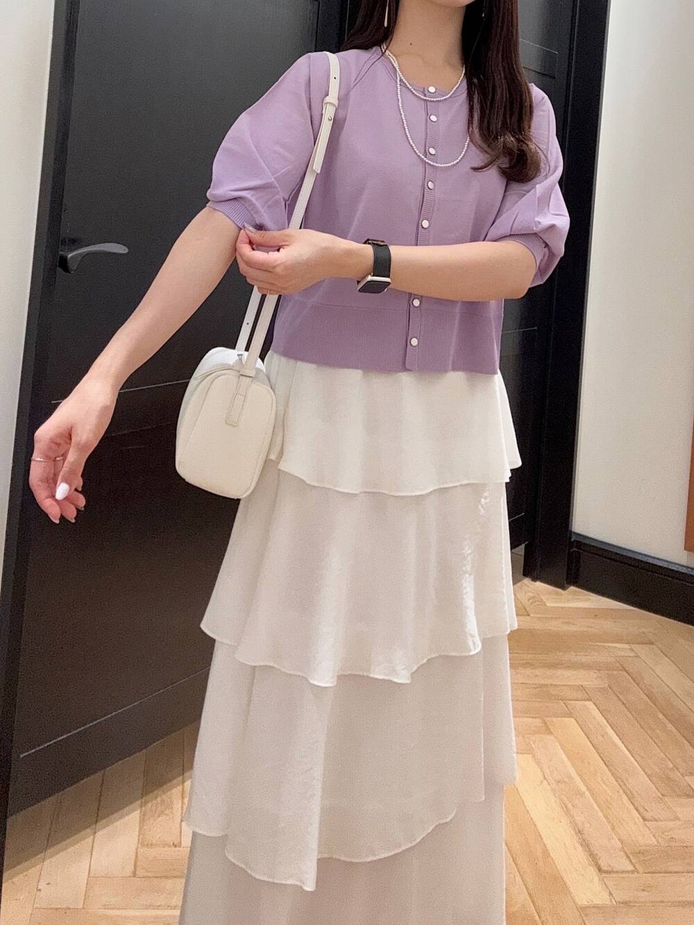 ホワイト系のハンドバッグ、ブラック系のスニーカー、シルバー系のネックレスを着用したレディースの夏コーディネートの5枚目の写真