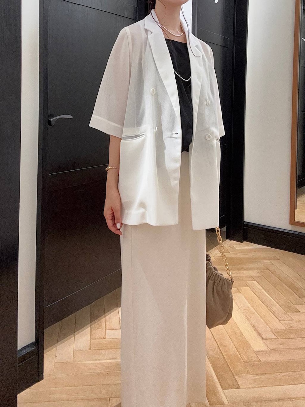 ホワイト系のテーラードジャケット、ブラック系のセットアップ、ブラウン系のパンプスを着用したレディースの夏コーディネートの5枚目の写真