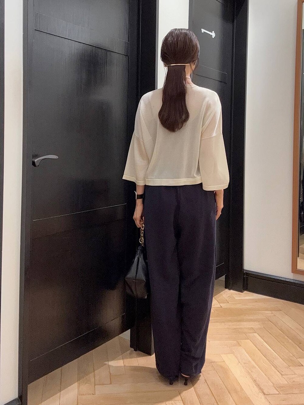 ブルー系のスウェットパンツ、ホワイト系のニット/セーター、ブラウン系のパンプスを着用したレディースの夏コーディネートの3枚目の写真