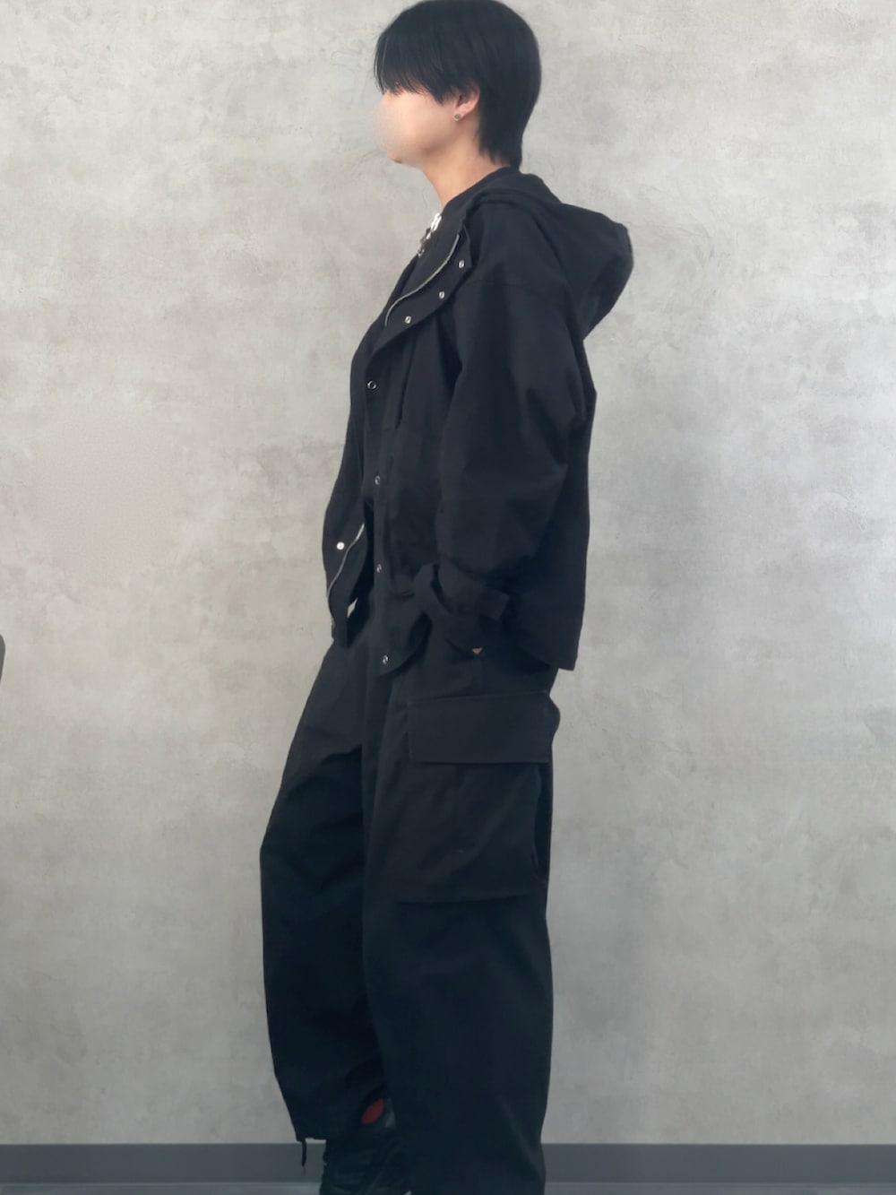 ブラック系のマウンテンパーカー、ブラック系のカーゴパンツ、シルバー系のネックレスを着用したメンズの冬コーディネートの2枚目の写真