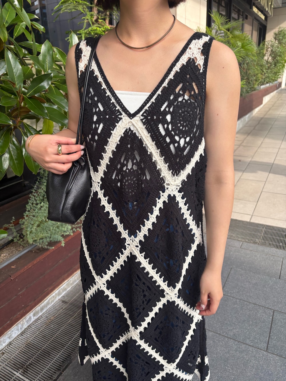 ブラック系のチュニック、ブルー系のデニムパンツを着用したレディースの夏コーディネートの2枚目の写真