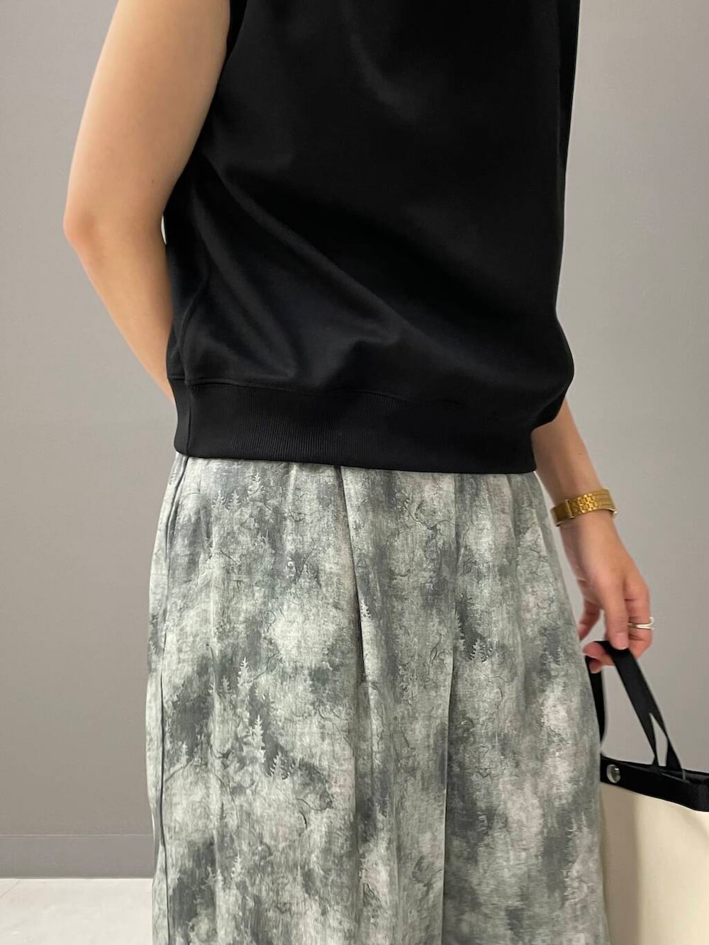 ホワイト系のサンダル、ブラック系のTシャツ/カットソー、ホワイト系のショルダーバッグを着用したレディースの夏コーディネートの6枚目の写真