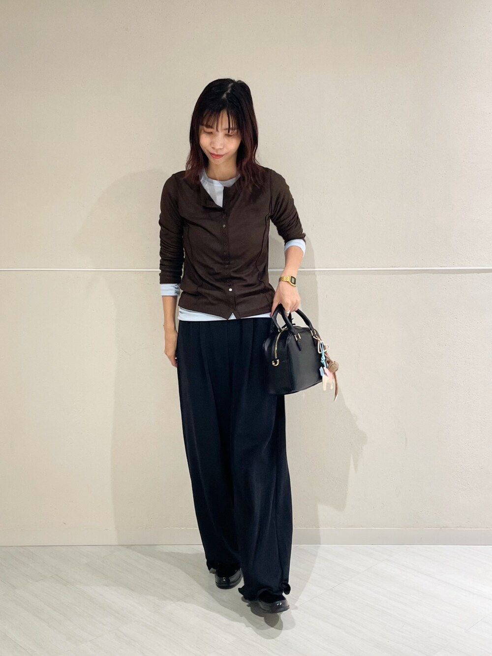 ブラック系のボストンバッグ、ブラック系のその他パンツ、ブラック系のレインシューズを着用したレディースの秋コーディネートの2枚目の写真