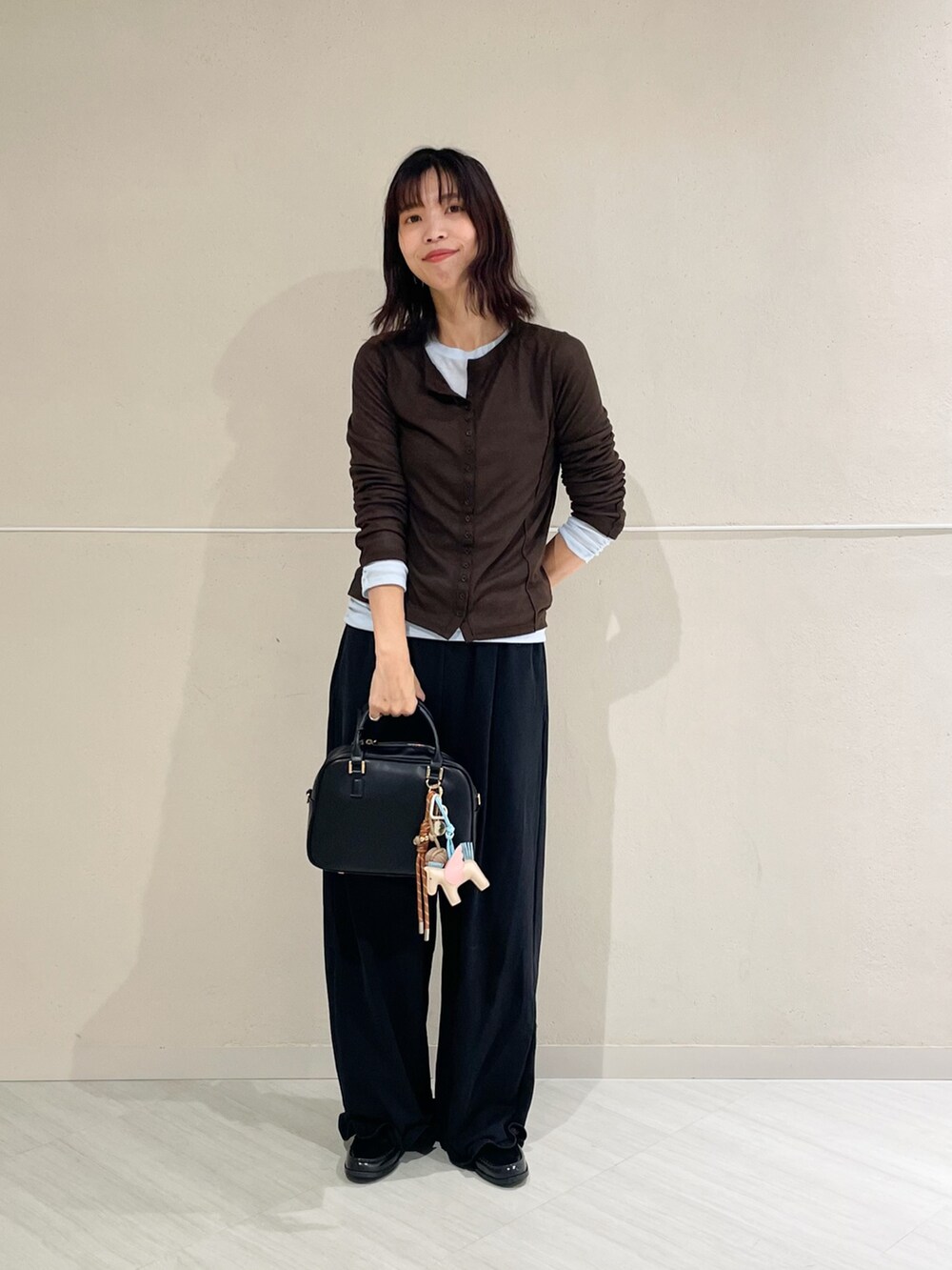 ブラック系のボストンバッグ、ブラック系のその他パンツ、ブラック系のレインシューズを着用したレディースの秋コーディネートの3枚目の写真
