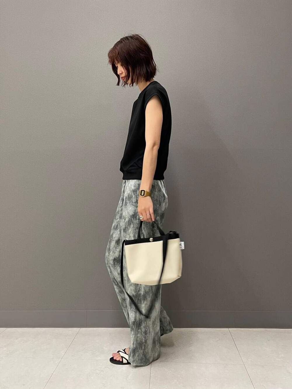 ホワイト系のサンダル、ブラック系のTシャツ/カットソー、ホワイト系のショルダーバッグを着用したレディースの夏コーディネートの4枚目の写真